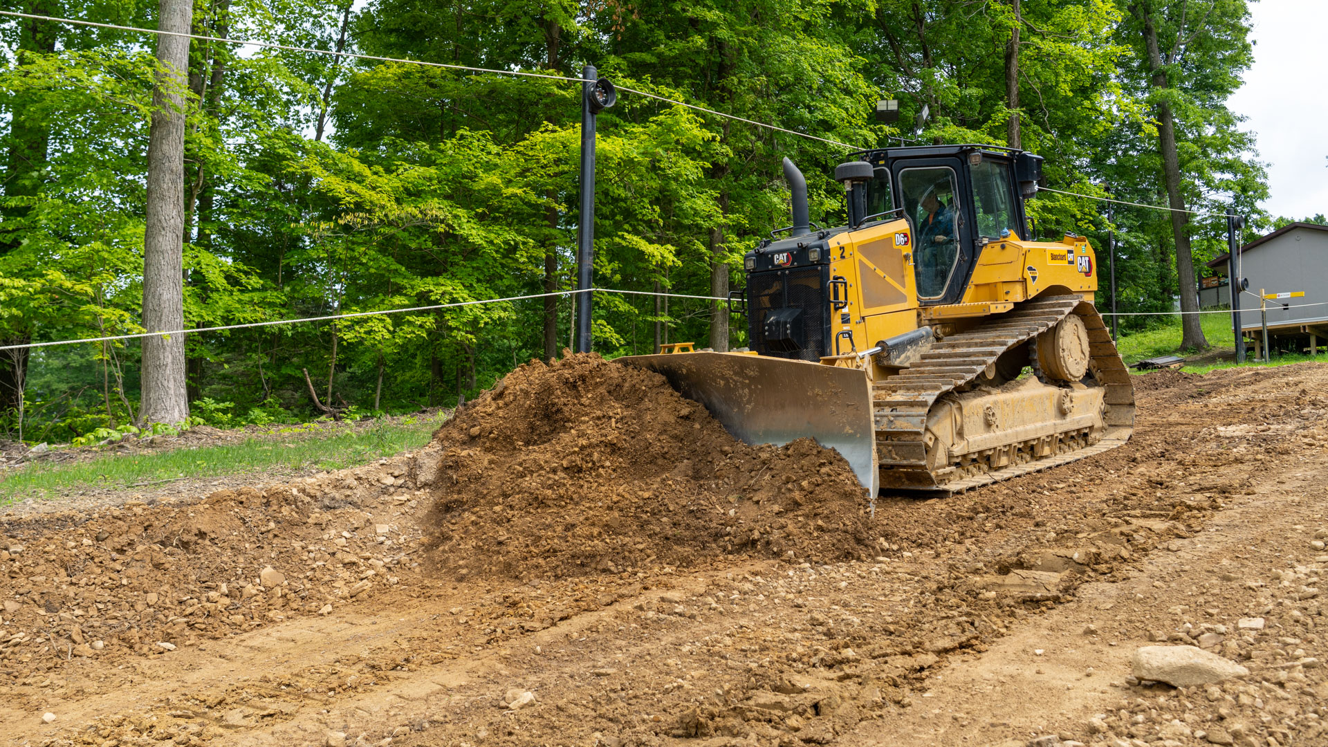 Side view of Bulldozer cutting knuckle out of dirt under The Woods Rope Tow at Snow Trails near Mansfield, Ohio