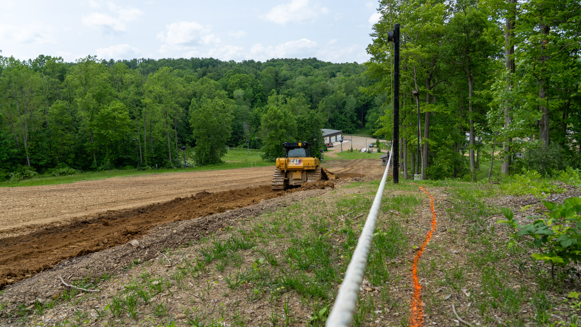 Bulldozer cutting knuckle out of dirt under The Woods Rope Tow at Snow Trails near Mansfield, Ohio