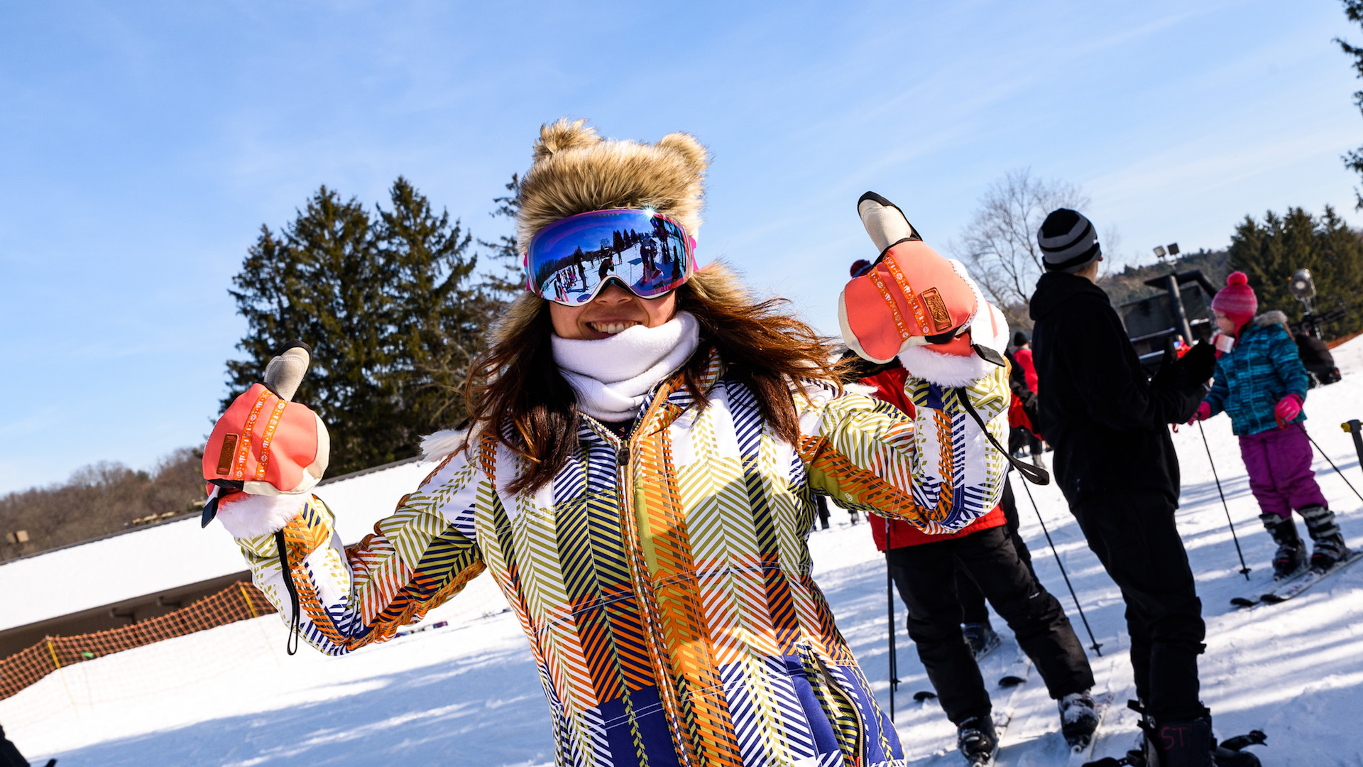 Smiling Skier with Fury Hat and Two Thumbs Up