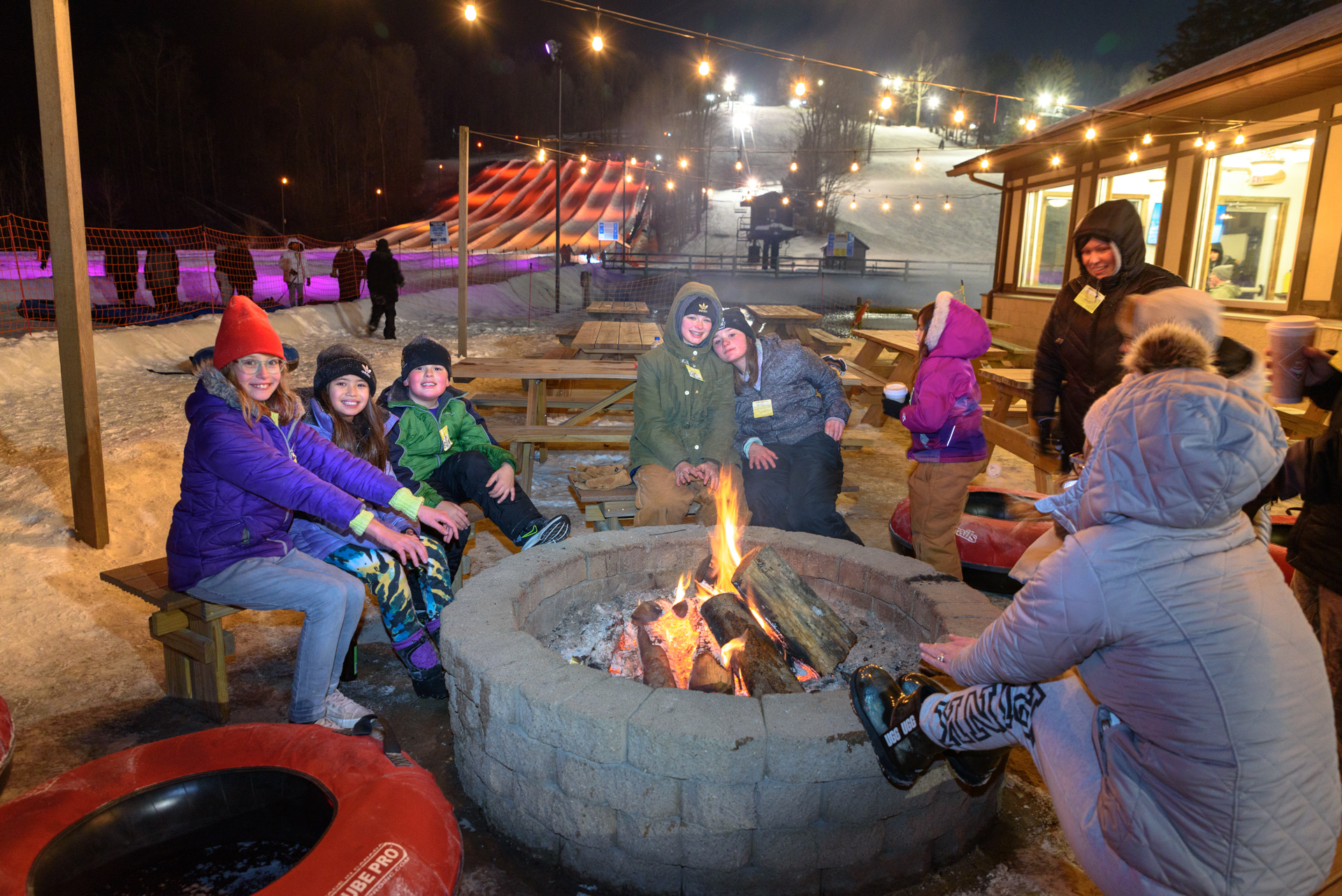 Tubing Lodge Fire Ring with Glow Tubing in Background